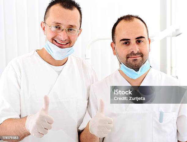 Retrato De Dos Sonriendo Médico De Pie Con Las Manos Doblado Foto de stock y más banco de imágenes de Adulto