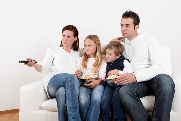 istock Cheeful young family watching TV at home 178179556