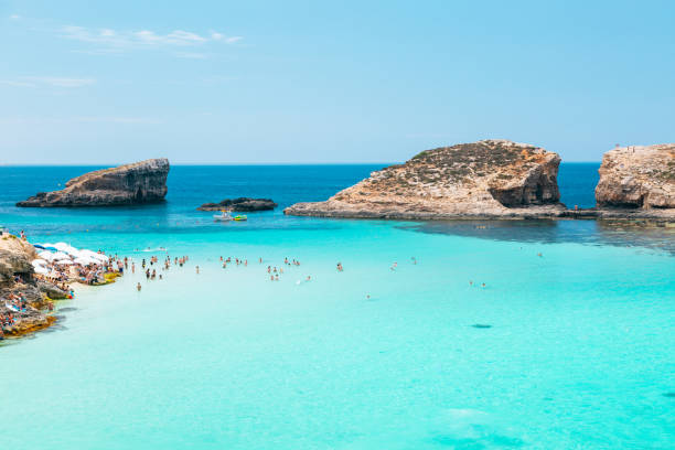 le blue lagoon - plage aux eaux cristallines et aux formations rocheuses sur l’île de comino, à malte. - vibrant color summer rock cliff photos et images de collection