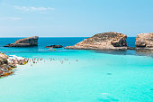 The Blue Lagoon - Beach with crystal clear water and rock formations on Comino island, Malta.