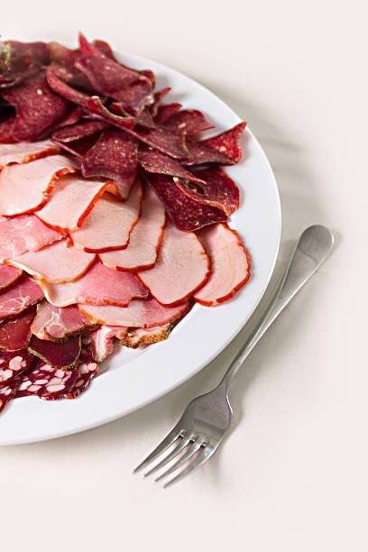sliced sausages and ham on a plate stock photo