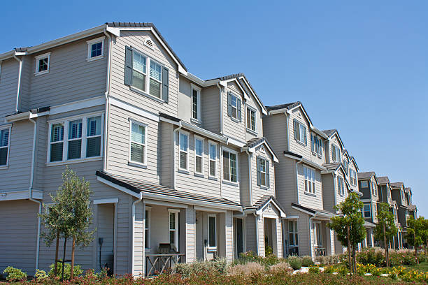 Row of three story town homes with landscaped lawns A row of new townhomes / condominiums, in Morgan Hill, California. townhouse stock pictures, royalty-free photos & images