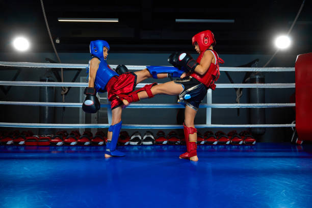 Children, two boy fighting on ring at gym. Performing punches, kicking and tricks. Professional sportsmen. Concept of sport, healthy lifestyle, hobby, fitness workout, competition.