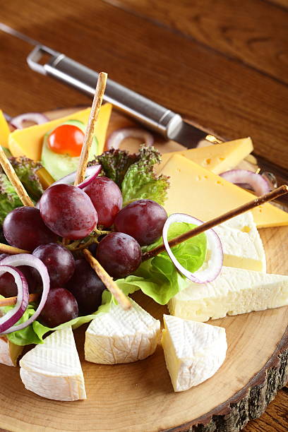 istock wooden dish with cheese and fruits 178183134