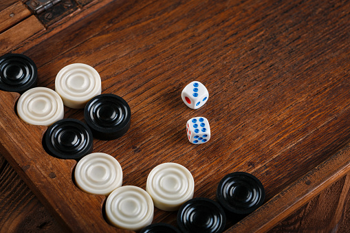 Backgammon. Game field in a backgammon with cubes and counters. Game concept. Board game. Hobby. Dice and checkers on the playing field for a game of backgammon.