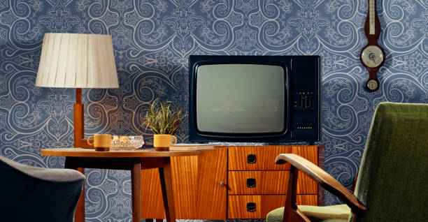 Interior view of living room with television on cabinet and coffee cups on table.