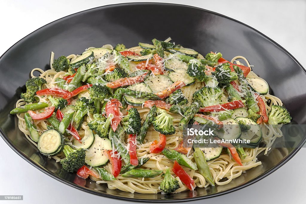 Large bowl of pasta primavera on a white background A large bowl of colorful healthy pasta primavera is on a white background.  This is one image in a series of pasta primavera images. Asparagus Stock Photo