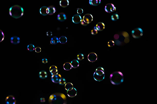 The transparent, iridescent soap bubbles isolated on black. Background
