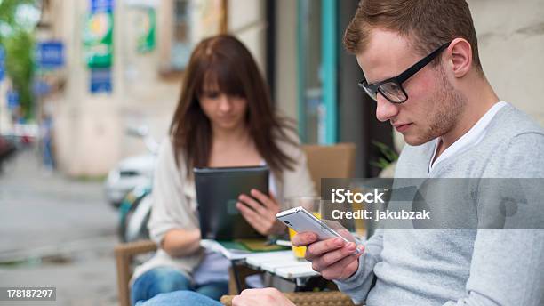 Hombre Con Teléfono Celular Y Mujer Sentada En Una Cafetería Foto de stock y más banco de imágenes de Adicción