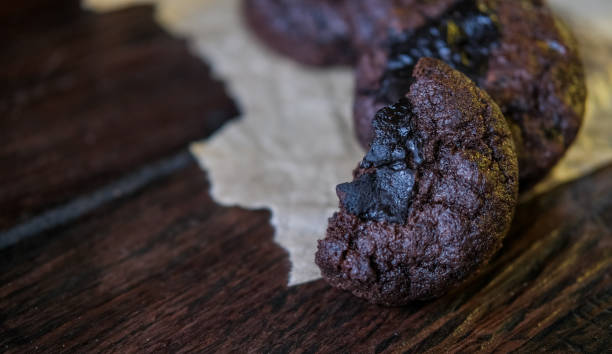 istock Bitten dark chocolate chip cookies on baking paper over wooden rustic background 1781876860