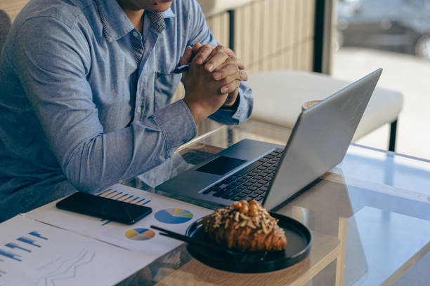 istock Young Asian businessman working with laptop, checking graphs, company budget reports, production control. Operational inspection cost plus price Close-up pictures 1781880902