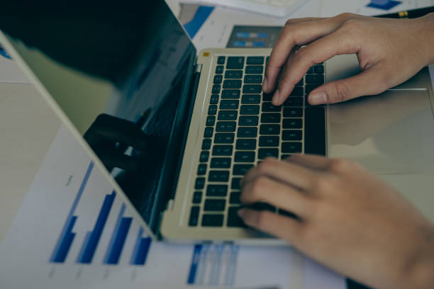 istock Young Asian businessman working with laptop, checking graphs, company budget reports, production control. Operational inspection cost plus price Close-up pictures 1781880924