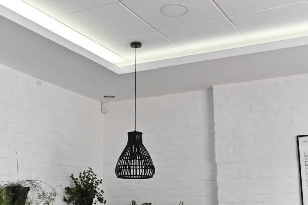 istock A beautiful lamp on a long wire hangs on the ceiling. against a white wall. 1781881507