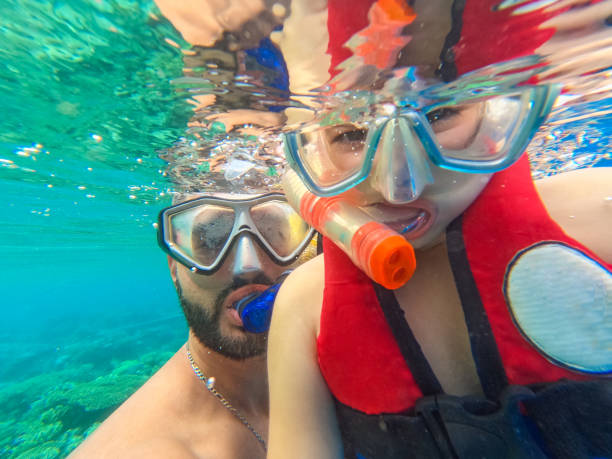 Young Father Taking A Selfie With His Daughter While Snorkeling In The Red Sea In Egypt Handsome young father taking a selfie with his daughter while snorkeling in the Red sea in Hurghada in Egypt. scuba diving family stock pictures, royalty-free photos & images