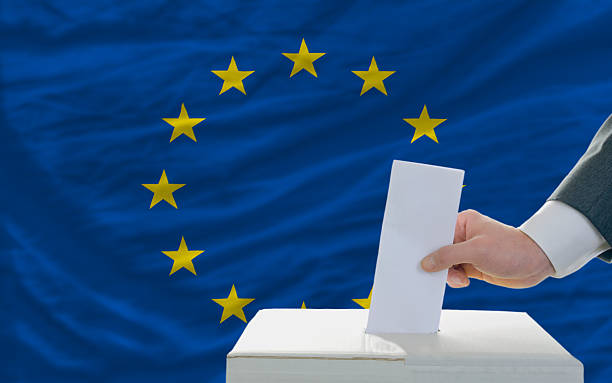 istock Man's hand putting ballot in box in EU election 178189561