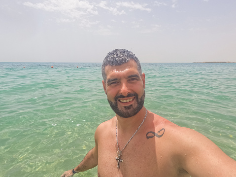 Handsome young man taking a selfie in the Red sea in Hurghada in Egypt.