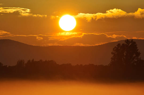 Puesta de sol sobre el río en la niebla - foto de stock