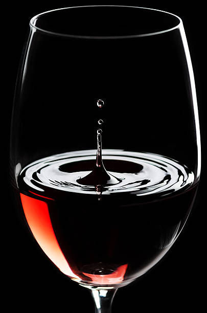 Red wine drips in a wineglass stock photo