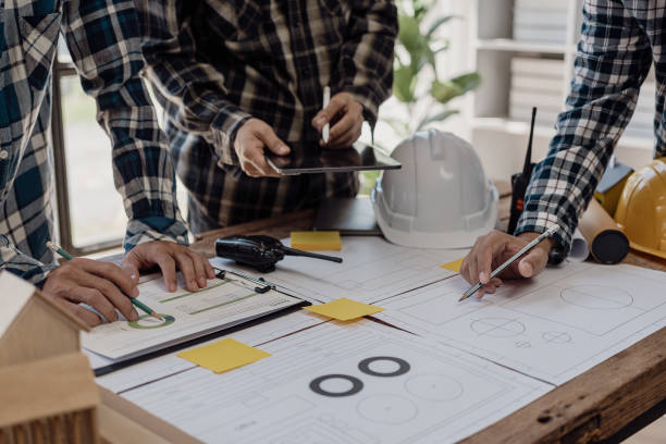 istock Engineer points to building on blueprint and uses laptop to draw building design project in office Image engineer concept of engineer meeting for architectural project Work with partners 1781918624