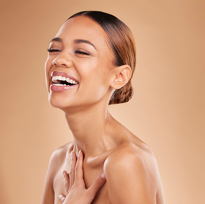 Happy, beauty and a woman laughing for skin glow and shine in studio on a brown background. Face of aesthetic female model satisfied with spa facial, dermatology cosmetics and wellness with skincare
