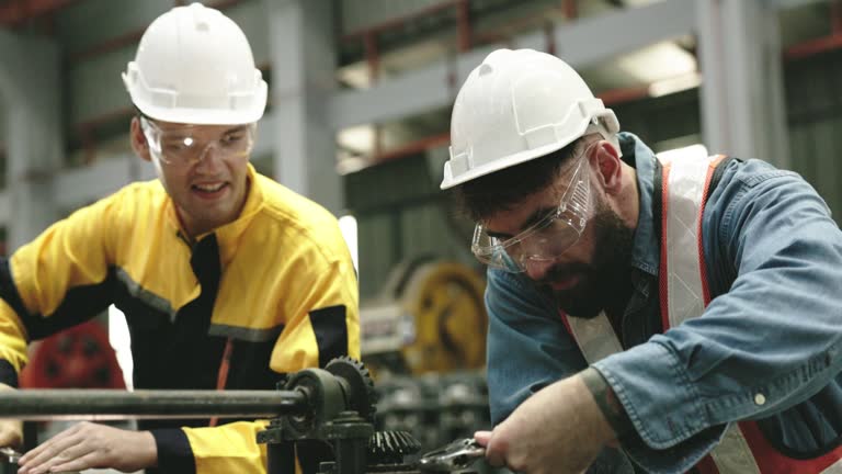 Engineers inspecting machines repairing them profession safety helmet to prevent