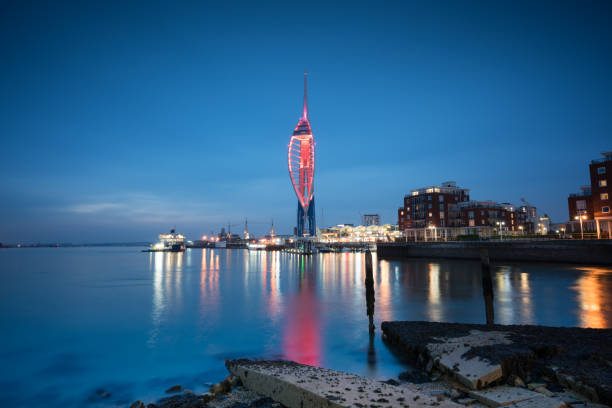 This captivating image captures the iconic Spinnaker Tower and the vibrant Gunwharf Quays in Portsmouth as they bask in the gentle light of dusk. The city's landmarks and waterside charm are beautifully illuminated, creating a scene of urban sophistication and maritime allure.