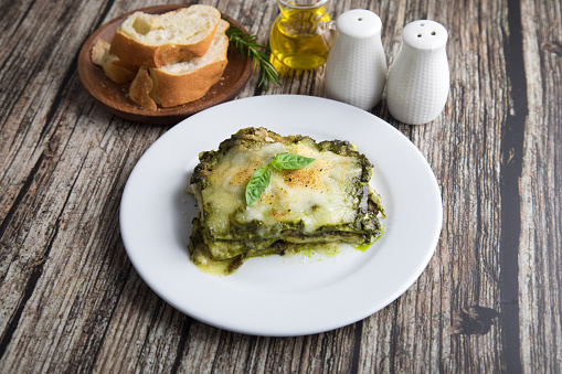 Personal portion of pesto lasagna italian food fusion served on a white plate