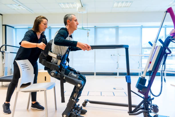 istock Mechanical exoskeleton. Physiotherapy medical assistant lifting disabled person with robotic skeleton to get up. Futuristic rehabilitation, Physiotherapy in a modern hospital 1781956401