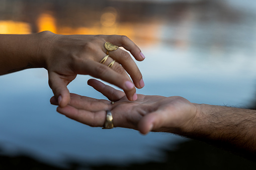 Detail of fingers of a boy and a girl caressing each other in the street