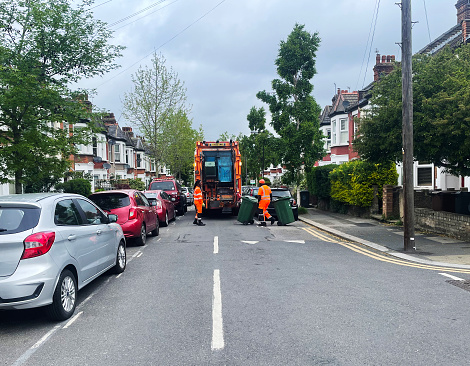 Garbage man at work, Recycling garbage collector truck loading waste and trash bin