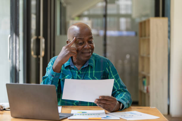 istock Serious senior experienced financier checking reports, African American businessman in business suit concentrating thinking working with contracts and invoices, paperwork inside the office. 1781995998