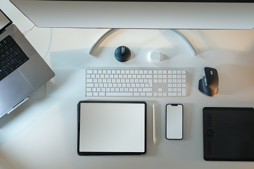 Smart devices blank screen mockup. Home studio office desktop. Table from above. Top view. Screen mockup. Graphic tablet, mobile phone, display monitor, laptop.