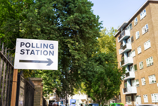 A sign in central London directing people towards a polling station for voting in a UK general election.