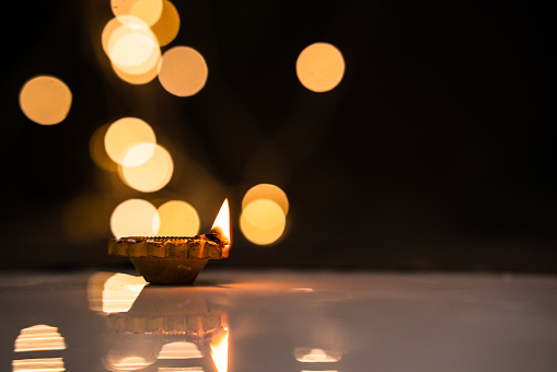 Diwali concept background, Diwali Diya lit isolated on bokeh background with copy space