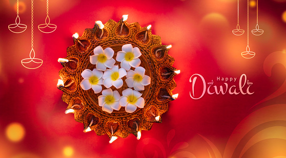 Happy Diwali 2024 concept image, Beautiful traditional Diya lamp with flowers on the background