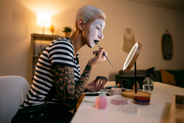 istock Young woman, a mime artist, applying face paint while getting ready for pantomime show. 1782073945