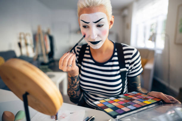istock Young woman, a mime artist, applying face paint while getting ready for pantomime show. 1782075078
