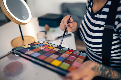 An unrecognizable make-up artist working at her studio.