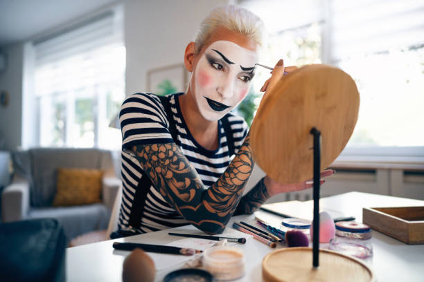 istock Young woman, a mime artist, applying face paint while getting ready for pantomime show. 1782076776