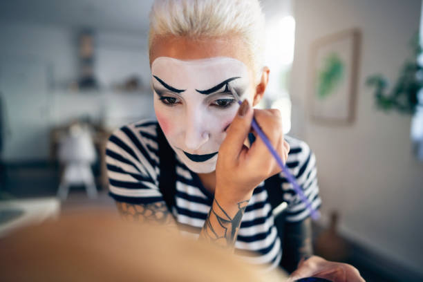 istock Young woman, a mime artist, applying face paint while getting ready for pantomime show. 1782076786