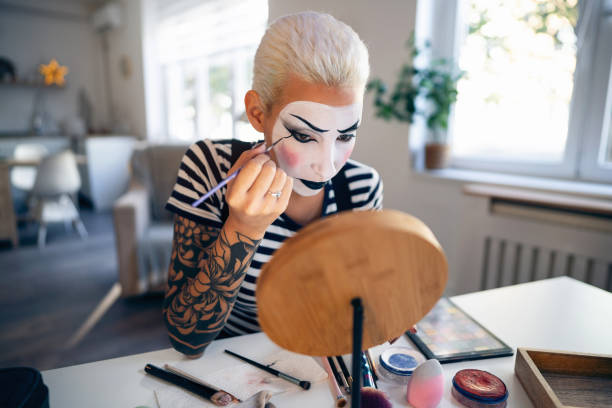 istock Young woman, a mime artist, applying face paint while getting ready for pantomime show. 1782076788