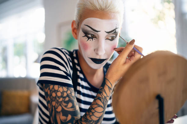 istock Young woman, a mime artist, applying face paint while getting ready for pantomime show. 1782076792