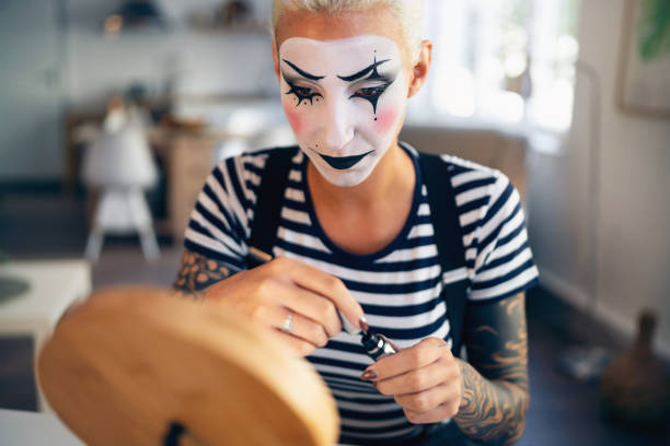 istock Young woman, a mime artist, applying face paint while getting ready for pantomime show. 1782077314