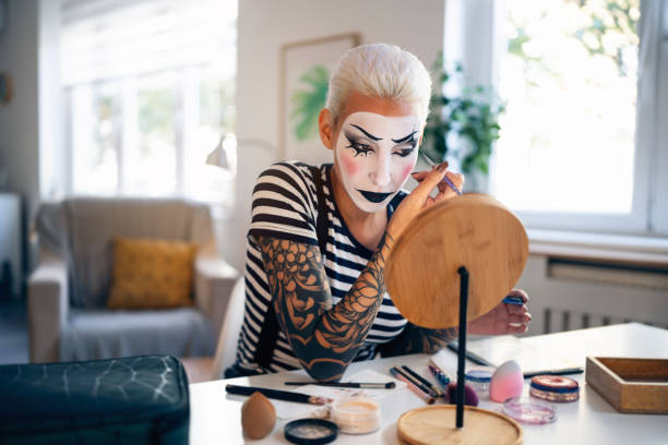 istock Young woman, a mime artist, applying face paint while getting ready for pantomime show. 1782077320