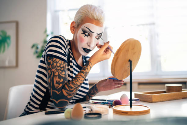 istock Young woman, a mime artist, applying face paint while getting ready for pantomime show. 1782077321