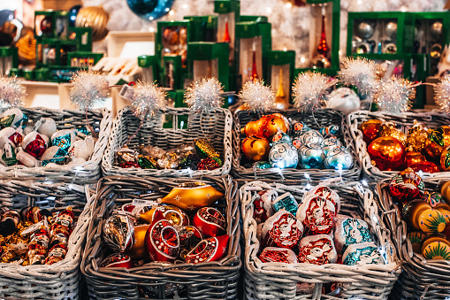 Winter festive shopping. Holiday market with colorful holiday Christmas toys and souvenirs in the wicked basket.