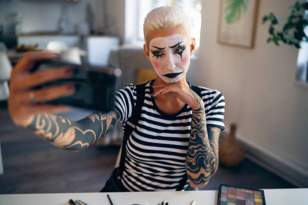 giovane donna, un'artista mima, che scatta selfie a casa mentre si prepara per lo spettacolo di pantomima. - clown mime sadness depression foto e immagini stock