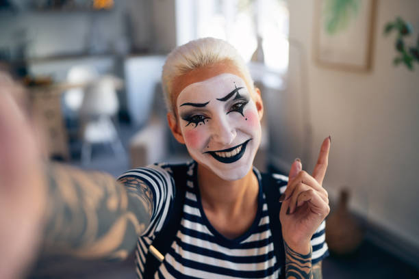 Young woman, a mime artist, taking selfies at home while getting ready for pantomime show.