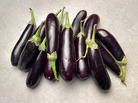 High angle view fresh eggplants on gray stone background with copy space