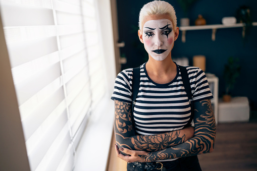 Portrait of young woman, a mime artist, at home.
